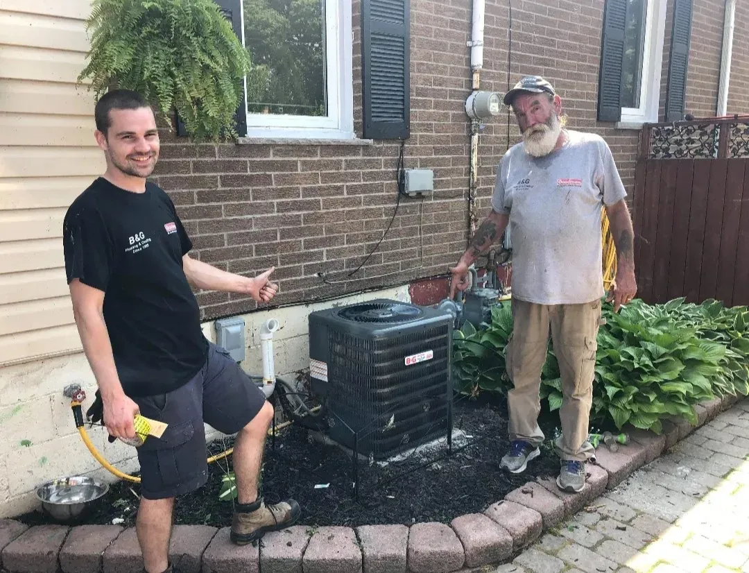 Spring Air Conditioner Tune-Up Checklist 3 HVAC technician inspecting air conditioning unit for energy efficiency